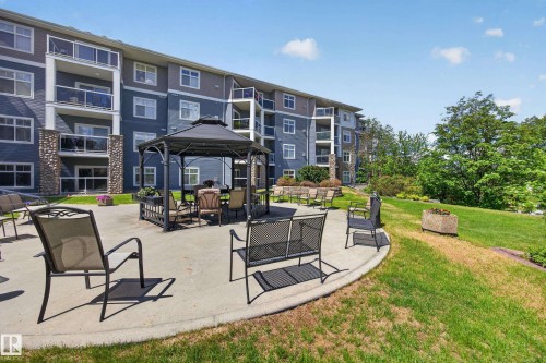 Outdoor patio area featuring a fixed gazebo, concrete hardscaping, and surrounding green space - 138 16035 132 Street, Edmonton, AB 