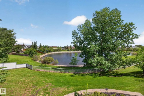 Expansive green lawn with mature trees and a stone-edged garden bed - 138 16035 132 Street, Edmonton, AB 