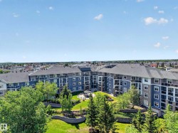 Multi-story residential complex featuring blue and gray siding with stone accents - 