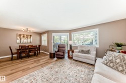 Open-concept living and dining area featuring wood-finish flooring, neutral wall tones, and recessed lighting - 