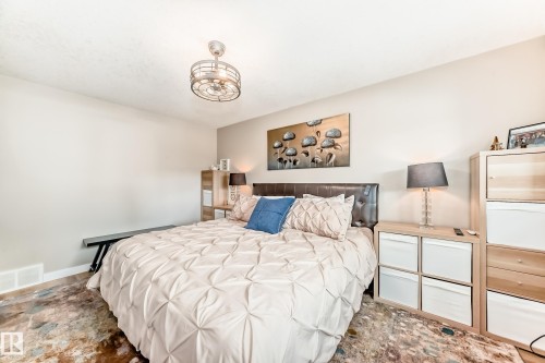 Spacious room featuring wood-finish flooring, a contemporary ceiling fan, and ample wall space - 10822 11 Avenue, Edmonton, AB 