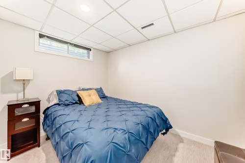 Brightly lit room featuring a drop ceiling with recessed lighting, light-toned carpeting, and white baseboards - 10822 11 Avenue, Edmonton, AB 
