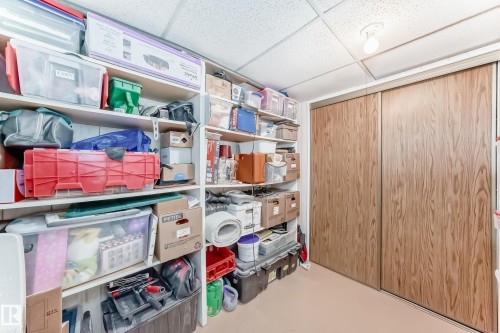 Storage area featuring built-in shelving and full-height sliding closet doors - 10822 11 Avenue, Edmonton, AB 