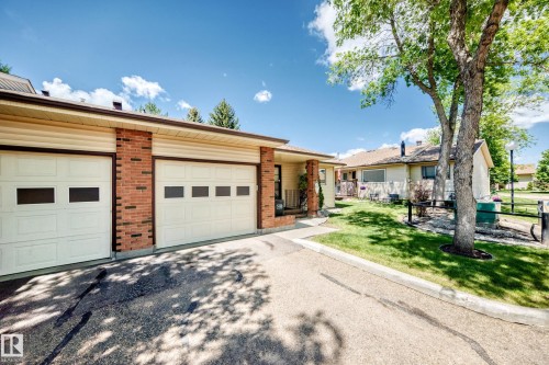 Brick facade with cream-colored garage doors featuring window inserts - 10822 11 Avenue, Edmonton, AB 