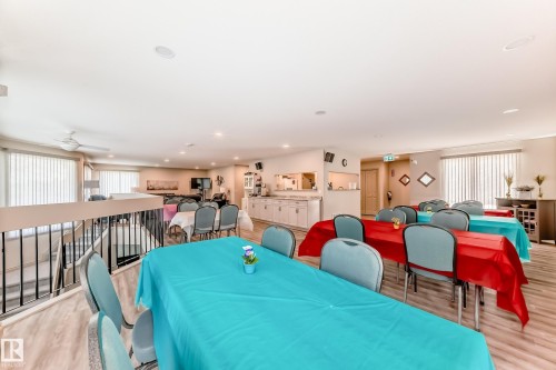 Open-concept upper level featuring wood-finish flooring, a white ceiling with recessed lighting, and vertical blinds on multiple windows - 10822 11 Avenue, Edmonton, AB 
