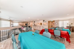 Open-concept upper level featuring wood-finish flooring, a white ceiling with recessed lighting, and vertical blinds on multiple windows - 