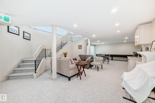 Spacious lower-level area featuring light-toned carpeting, recessed lighting, and a built-in wet bar with white cabinetry - 10822 11 Avenue, Edmonton, AB 