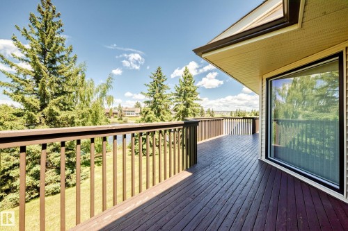 Expansive wooden deck with a dark-stained finish, featuring a matching railing system - 10822 11 Avenue, Edmonton, AB 