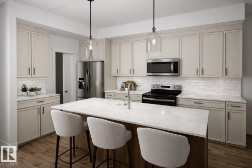 Open-concept kitchen featuring an island with seating, stainless steel appliances, light-toned cabinetry, white subway tile backsplash, and wood-finish flooring - 10417 104 Street, Morinville, AB - Indoor Photo Showing Kitchen With Double Sink With Upgraded Kitchen