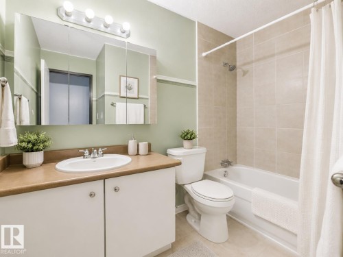 Bathroom featuring a white vanity with a brown countertop, white drop-in sink, and medicine cabinet with integrated lighting - 1 13450 Fort Road, Edmonton, AB 