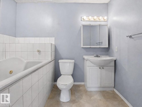 Full bathroom featuring a ceramic tile surround, pedestal sink with vanity storage, toilet, and ceramic tile flooring - #1 13450 Fort Rd Nw, Edmonton, AB - Indoor Photo Showing Bathroom