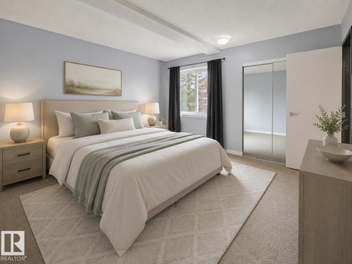 Carpeted bedroom featuring a window with dark drapery, a mirrored sliding closet door, and a light-toned wooden dresser - 1 13450 Fort Road, Edmonton, AB 