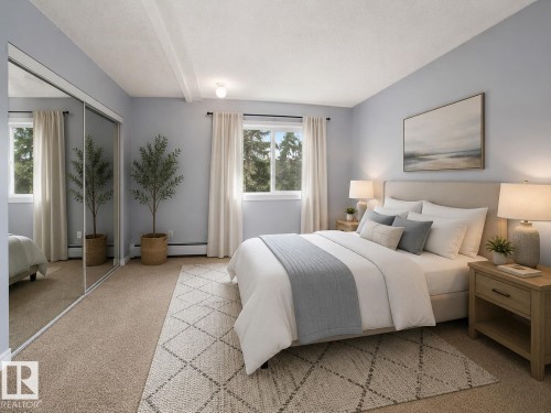 Spacious bedroom featuring dual windows, mirrored sliding closet doors, and recessed ceiling beams - 1 13450 Fort Road, Edmonton, AB 