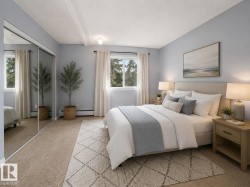 Spacious bedroom featuring dual windows, mirrored sliding closet doors, and recessed ceiling beams - 