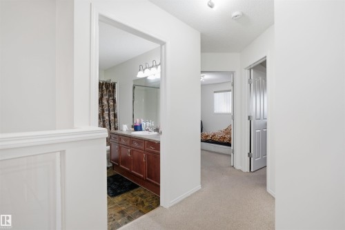 Hallway featuring carpeted flooring and white painted walls - 1560 37B Avenue, Edmonton, AB 