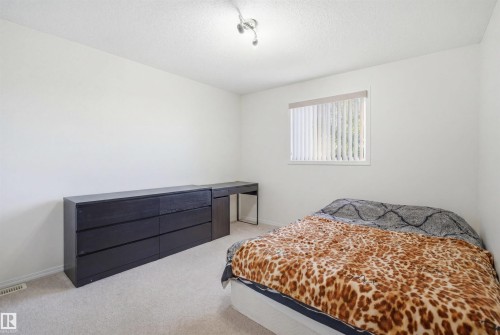 Bedroom featuring neutral carpet, white walls, and a window with vertical blinds - 1560 37B Avenue, Edmonton, AB 