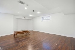 Spacious room featuring wood-finish flooring, recessed lighting, white walls, and a white trim baseboard - 