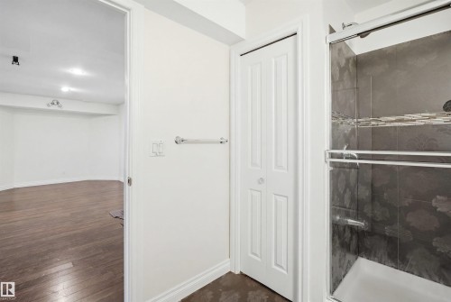 Compact three-panel bifold door, white walls, and wood-finish flooring - 1560 37B Avenue, Edmonton, AB 
