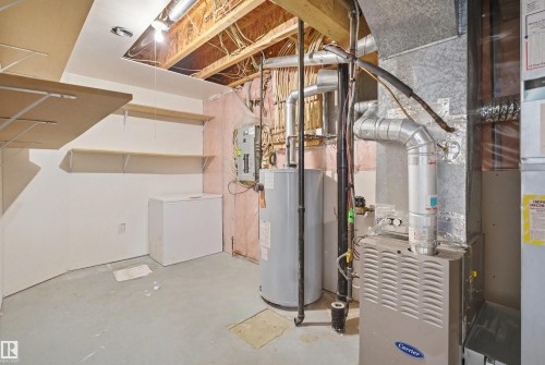 Utility room featuring a furnace, water heater, and exposed ceiling joists - 1560 37B Avenue, Edmonton, AB 