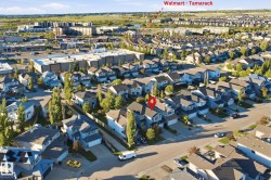Aerial perspective of a residential neighborhood featuring detached homes with attached garages and mature landscaping - 