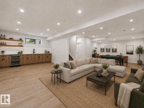 Spacious recreation room featuring light wood-finish flooring, recessed lighting, and a built-in wet bar with wood cabinetry and a beverage refrigerator - 3318 Chickadee Drive, Edmonton, AB 