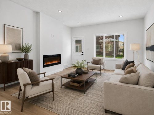 Spacious living area featuring light wood-finish flooring, recessed lighting, and a modern wall-mounted fireplace - 3318 Chickadee Drive, Edmonton, AB 