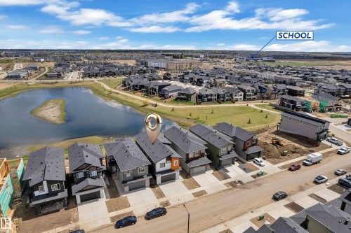 Modern residential development featuring a prominent water body, established parkland, and a nearby educational institution - 228 Linden Loop, Leduc, AB 