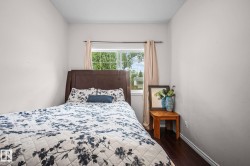 Bright room featuring a window with natural light, dark wood-finish flooring, and light-colored walls - 