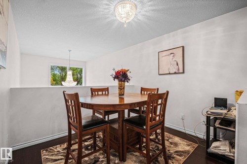 Open-concept loft space featuring a light-toned chandelier and a half-wall partition - 4806 117 Ave, Edmonton, AB 