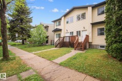 Townhome exterior with light-colored horizontal siding and dark trim - 