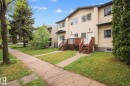 Townhome exterior with light-colored horizontal siding and dark trim - 4806 117 Ave, Edmonton, AB 