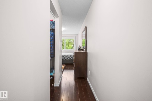 Hallway featuring dark wood-finish flooring, light-toned walls, and white trim - 4806 117 Ave, Edmonton, AB 