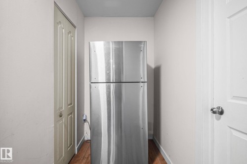 Stainless steel refrigerator with a top freezer, set within a neutral-toned alcove - 4806 117 Ave, Edmonton, AB 