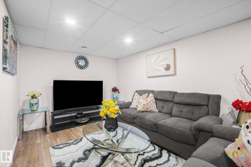 Finished living area featuring wood-finish flooring, recessed lighting, and a drop ceiling - 4806 117 Ave, Edmonton, AB 