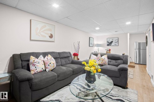 Open living area featuring light-toned walls, recessed lighting, and wood-finish flooring - 4806 117 Ave, Edmonton, AB 