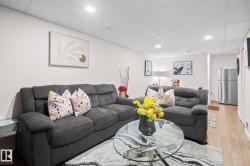 Open living area featuring light-toned walls, recessed lighting, and wood-finish flooring - 