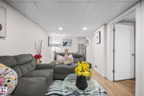 Spacious living area featuring light-toned walls, recessed lighting, and wood-finish flooring - 4806 117 Ave, Edmonton, AB 
