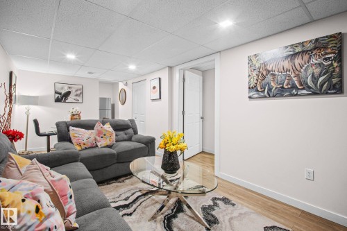 Finished living area featuring wood-finish flooring, recessed lighting, and a drop ceiling - 4806 117 Ave, Edmonton, AB 