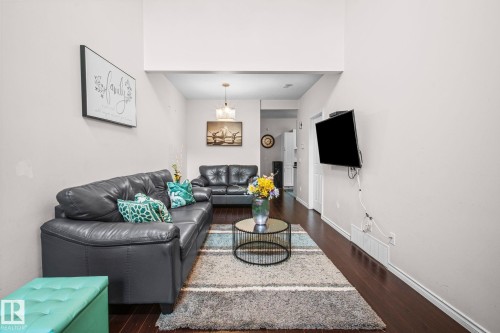 Living area featuring high ceilings and dark wood-finish flooring - 4806 117 Ave, Edmonton, AB 