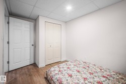 Room featuring wood-finish flooring, white walls, and a drop ceiling with recessed lighting - 