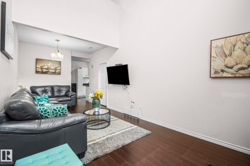 Living area featuring wood-finish flooring, vaulted ceiling, and recessed entry - 4806 117 Ave, Edmonton, AB 