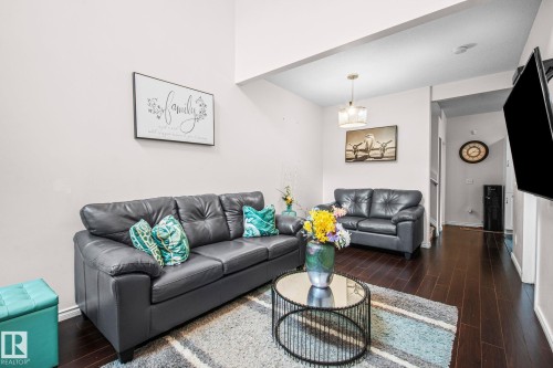 Living area featuring dark wood-finish flooring and light-toned walls - 4806 117 Ave, Edmonton, AB 