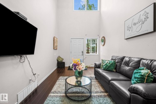 Living space featuring high ceilings, dark wood-finish flooring, and white walls - 4806 117 Ave, Edmonton, AB 