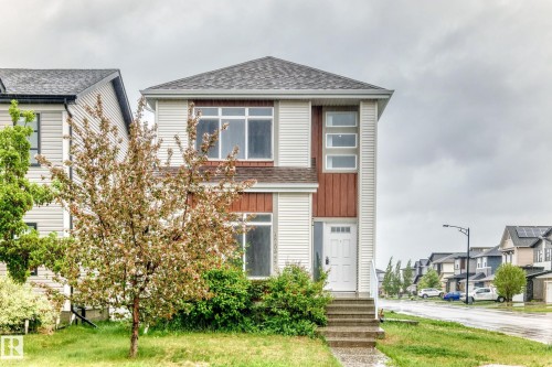 Modern two-story residence featuring light-colored siding with contrasting wood-finish accents - 18103 77 Street, Edmonton, AB 
