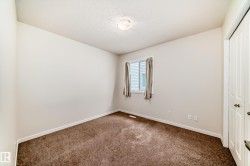 Bedroom featuring neutral wall paint, brown carpet flooring, a window with horizontal blinds, and a bi-fold closet door - 
