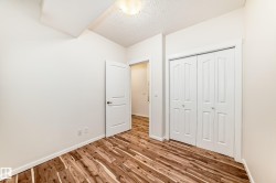 Wood-finish flooring throughout, bright white walls, and a recessed ceiling light fixture - 
