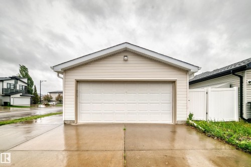 Detached garage with horizontal siding, a gabled roof, and a panel garage door - 18103 77 Street, Edmonton, AB 