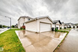 Detached garage with horizontal siding, a large white garage door, and a concrete driveway - 