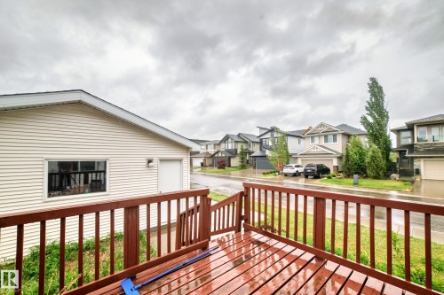 Wood-finish deck with railing overlooking a detached garage and residential street - 18103 77 Street, Edmonton, AB 