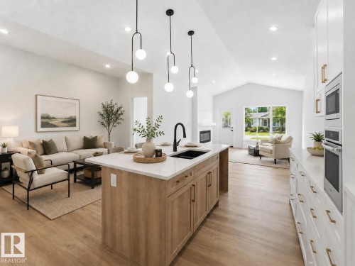 Open-concept living space featuring a central kitchen island with a dark sink and matte black faucet - 3320 Chickadee Drive, Edmonton, AB 